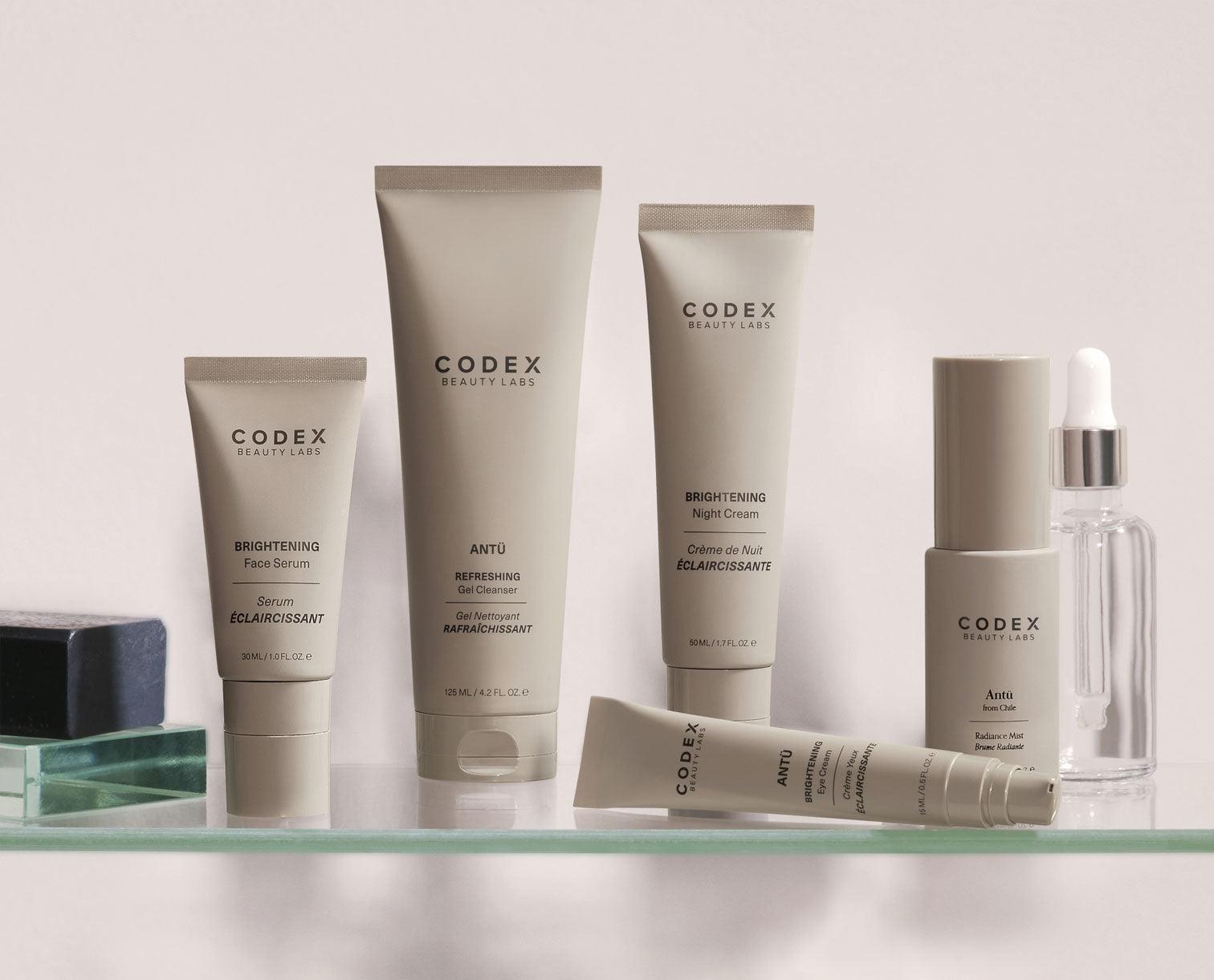 Image of the  range of Antu skincare bottles, placed on a glass bathroom shelf