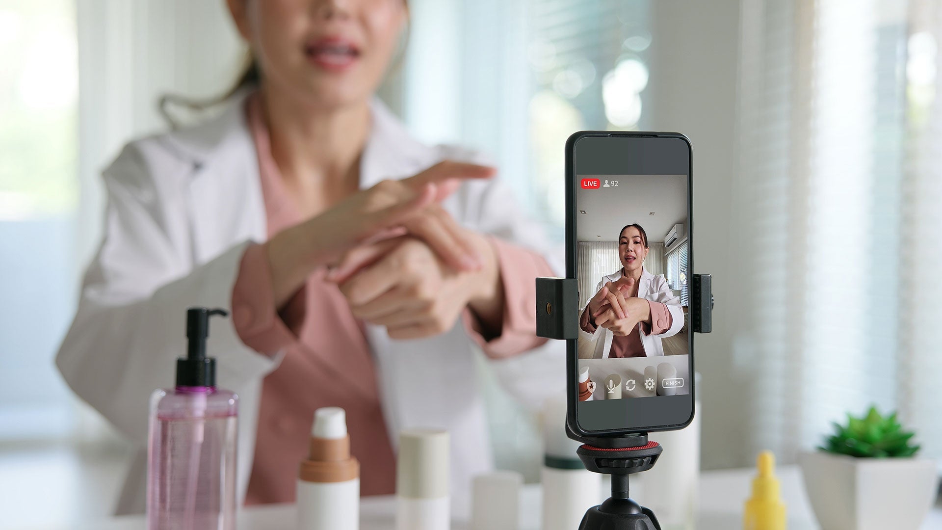 Dermotologist with a smart phone recording putting on a  topical